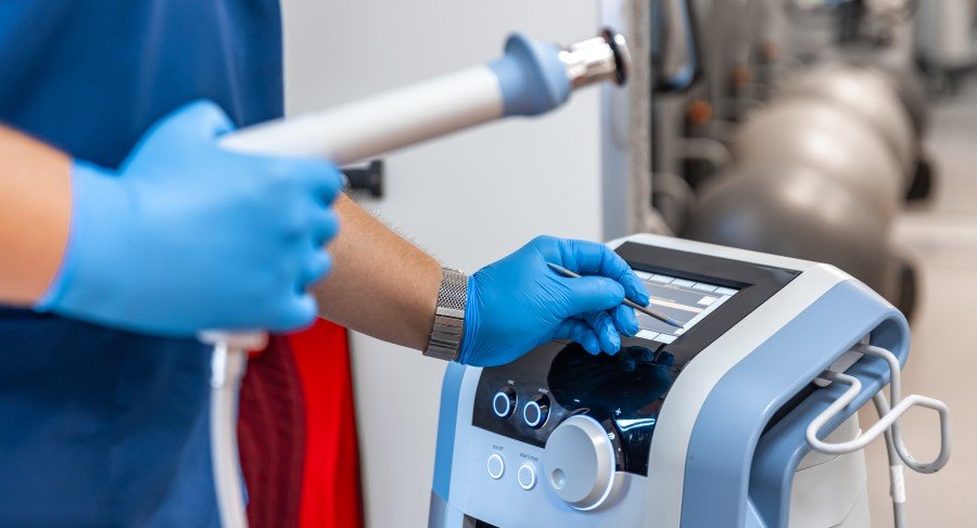 Medical equipment device being operated by a healthcare professional wearing blue gloves