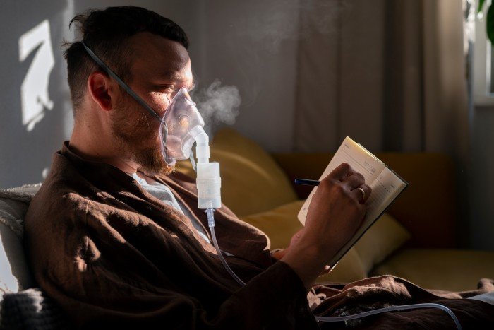 Man receiving respiratory support at home while using a breathing mask, relevant to BiPAP Machine on Rent services
